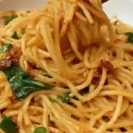 Delicious bowl of Chili Garlic Noodles garnished with fresh chilies and garlic