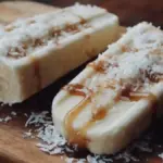 Delicious frozen banana coconut pops garnished with coconut flakes