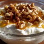 Bowl of Greek yogurt with honey and nuts garnished on top