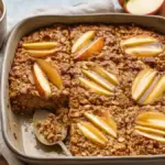 Healthy apple cinnamon baked oatmeal in a casserole dish topped with apple slices
