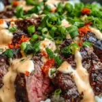 Korean BBQ Steak Rice Bowls topped with spicy cream sauce in a vibrant bowl