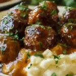 Salisbury steak meatballs served with garlic herb mashed potatoes on a plate