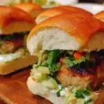 Veggie-loaded turkey sliders topped with fresh ingredients on a plate.