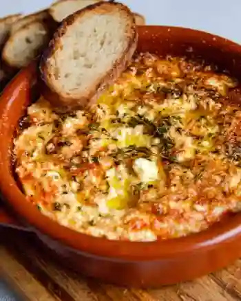 Creamy baked feta dip served with fresh vegetables and bread