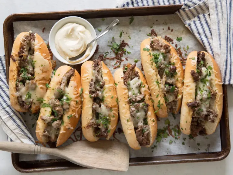 Delicious cube steak sandwich with toppings on a rustic wooden table