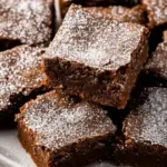 Deliciously spiced gingerbread brownies on a white plate.