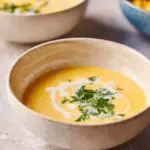 Bowl of Japanese corn soup garnished with green onions and served warm.