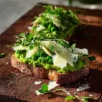 Bowl of pea and broad bean pesto served with fresh ingredients on the side