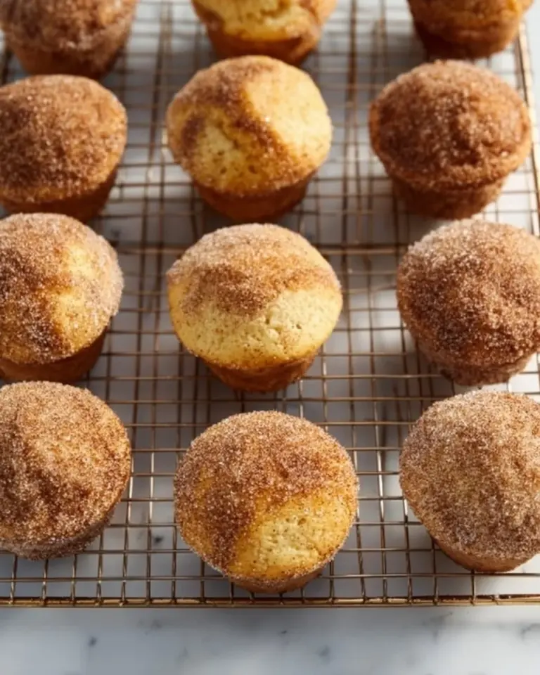 Freshly baked donut muffins with a sugary glaze on a cooling rack