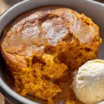 Delicious slow cooker pumpkin pie pudding served in a bowl with whipped cream