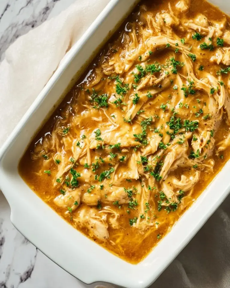 A plate of chicken and gravy served with mashed potatoes and vegetables