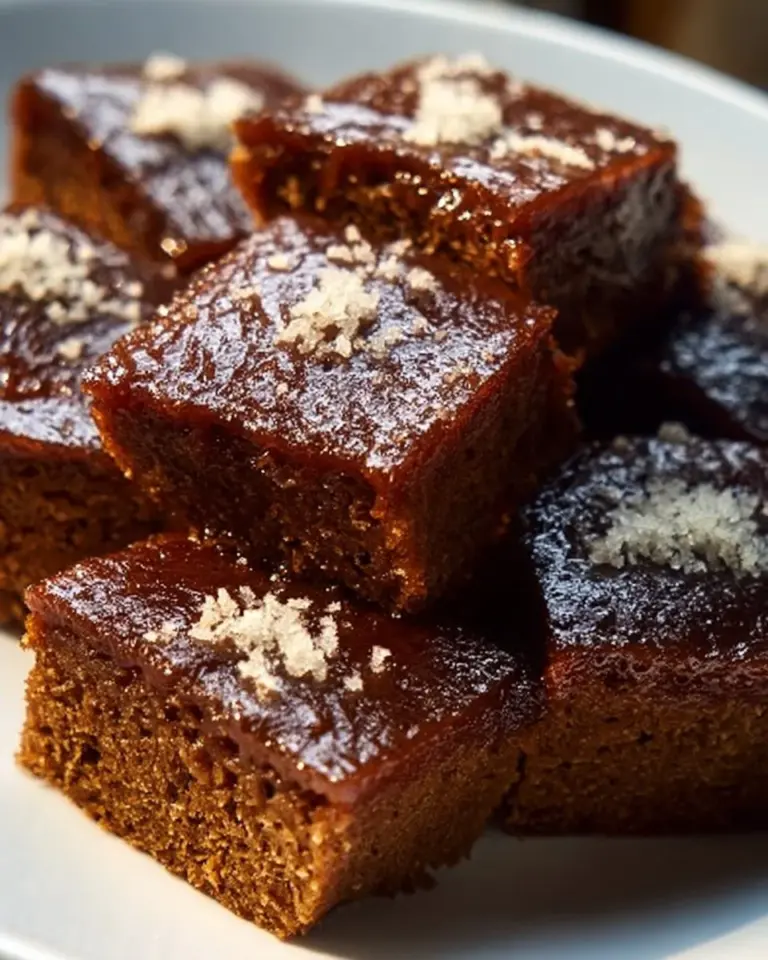 A slice of easy and moist gingerbread cake topped with cream icing and festive decorations.