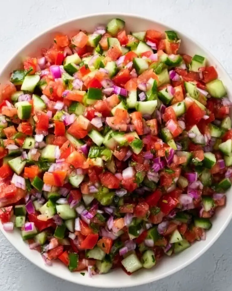 A bowl of colorful Shirazi Salad with tomatoes, cucumbers, and herbs