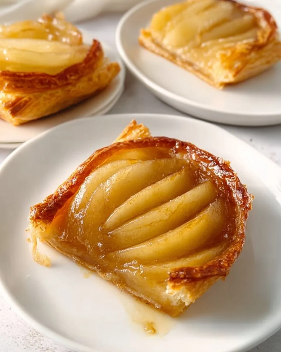 Upside-down puff pastry tarts with fruit topping on a rustic wooden table