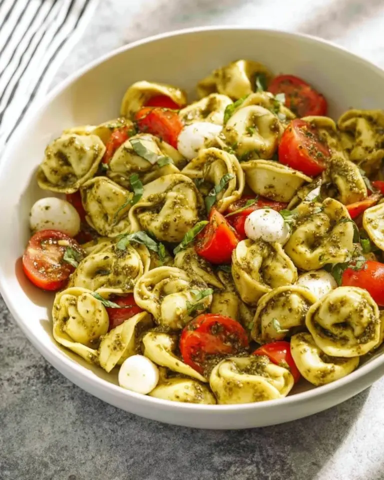 Plate of cheese tortellini with vibrant green pesto sauce