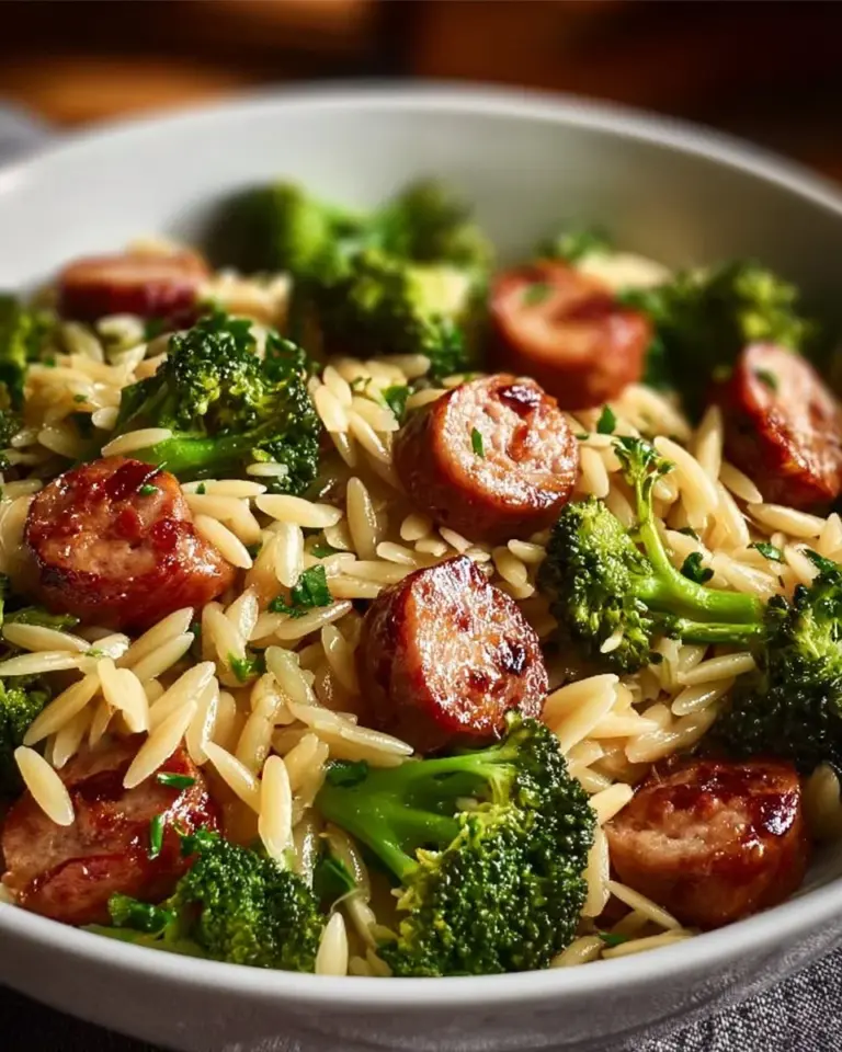 Chicken sausage and broccoli orzo dish topped with fresh herbs and spices