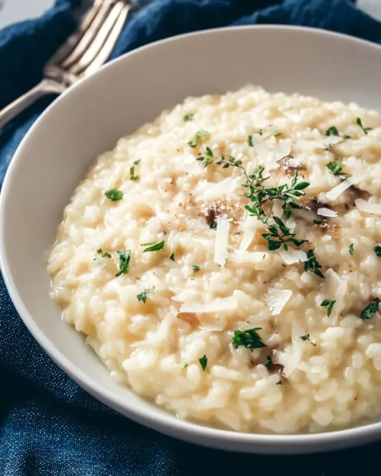 Serving of creamy Parmesan risotto in a bowl, garnished with parsley.