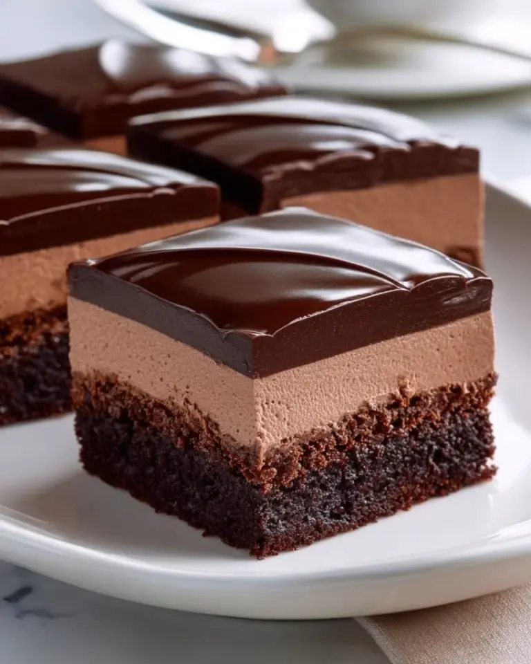 Decadent Brownie Mousse Cake topped with whipped cream and chocolate shavings