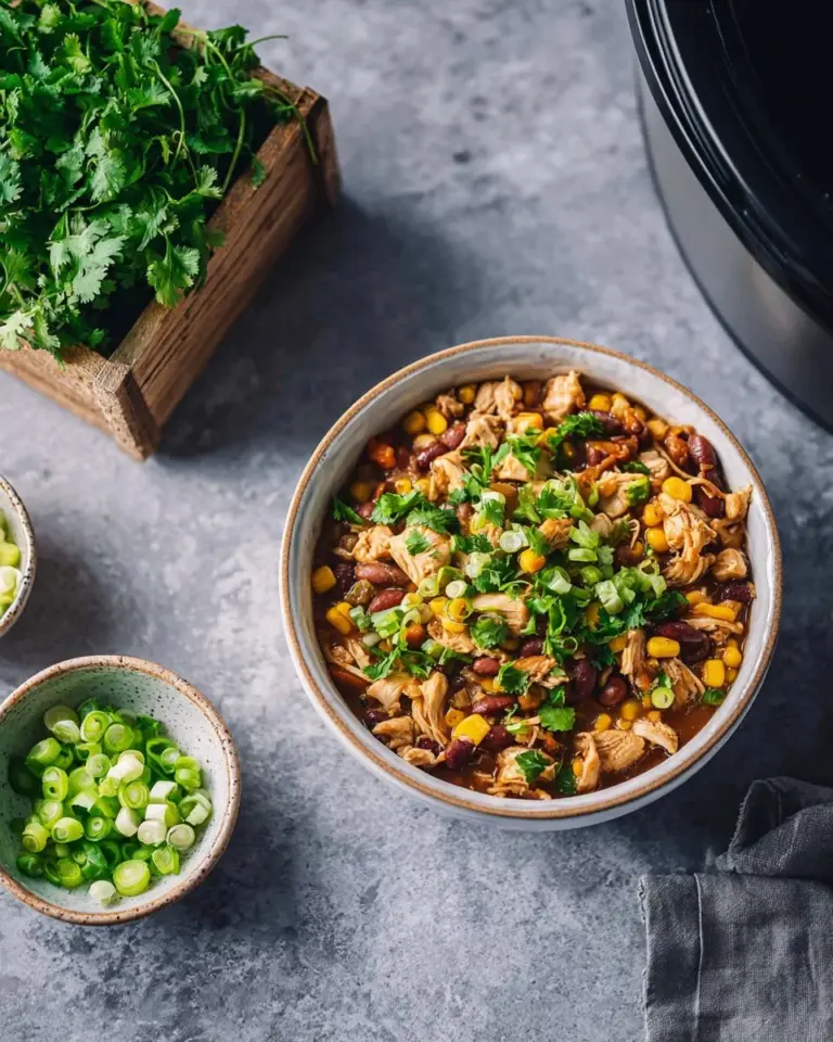 A bowl of easy white chicken chili topped with cilantro and sour cream
