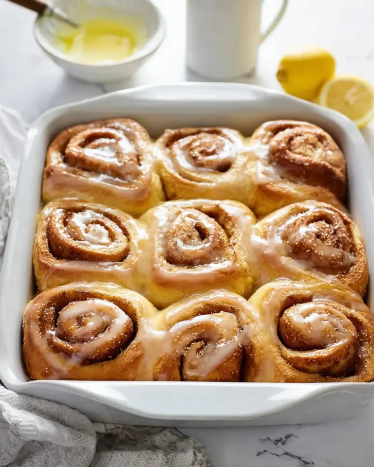 Freshly baked lemon poppy seed rolls arranged on a plate, showcasing their fluffy texture.